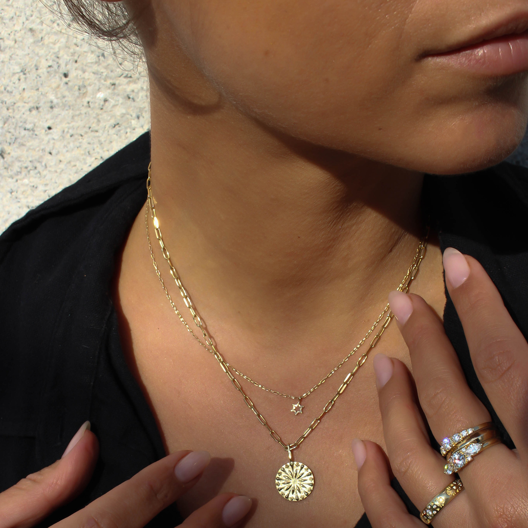 mini Magen david charm by Coh Jewelry two gold necklaces. closeup on body