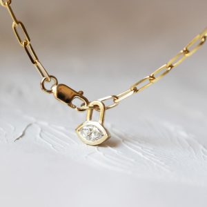 a gold chain with a diamond marquise pendant